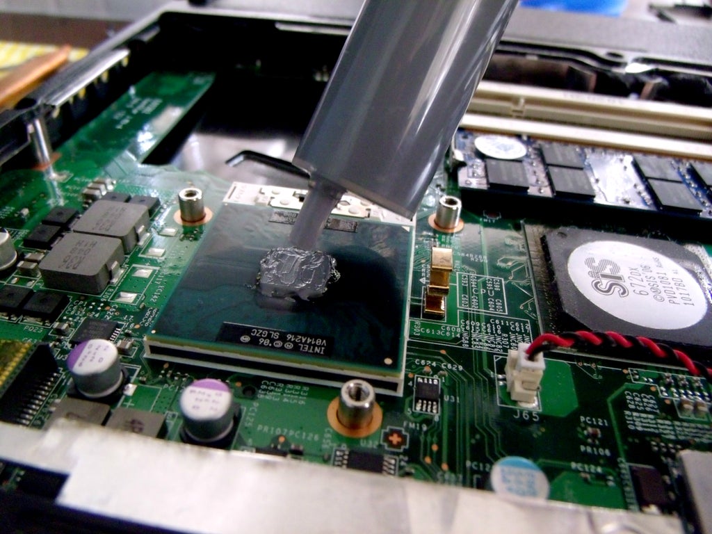 Applying thermal paste on a gaming laptop's processor.